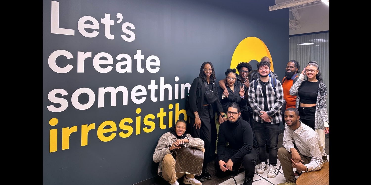 Group of students gathered around sign saying Let's Make Something Irresitible Group of students gathered around sign saying Let's Make Something Irresitible