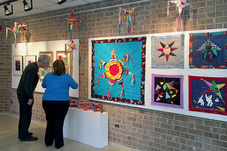 Image of CSU University Gallery with two people looking at fiber art