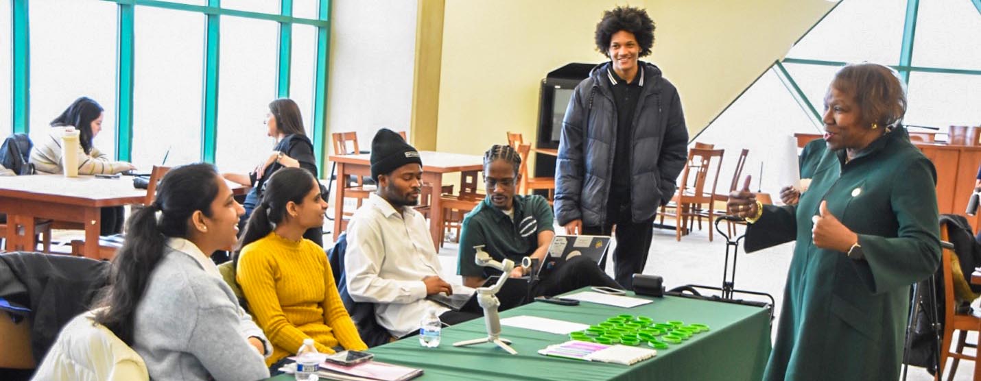 Chicago State University President Z. Scott speaks with a group of students in an engaging conversation.