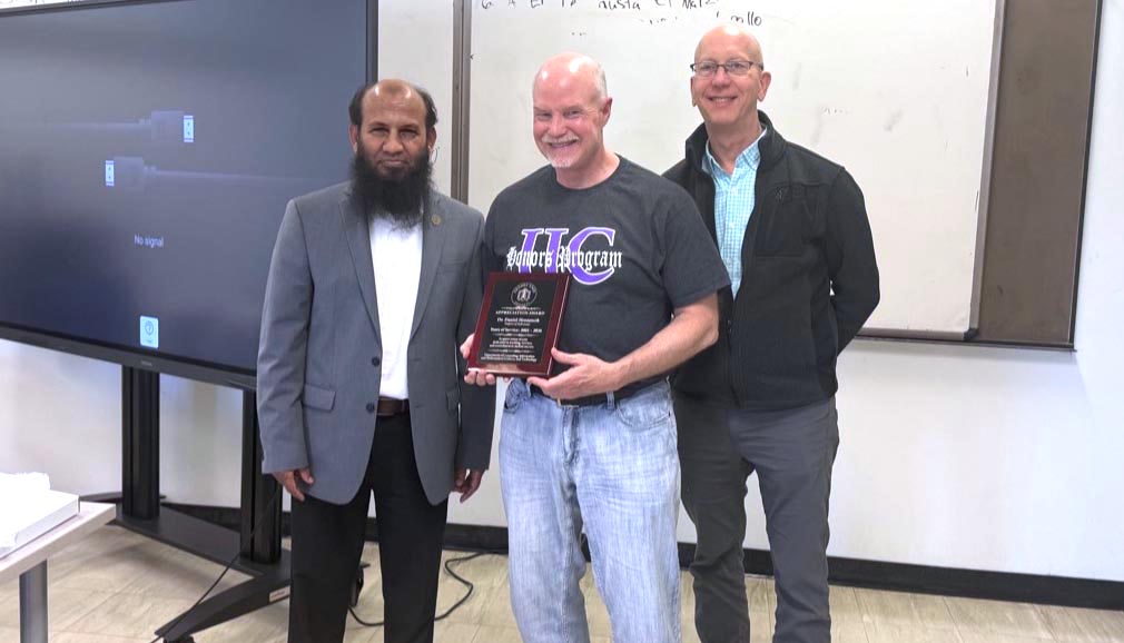 Dr. Hrozencik smiles while holding a plaque while CIMST chair Dr. Salam and Dean Mark Smith (College of Arts and Science) smile and stand alongside him.