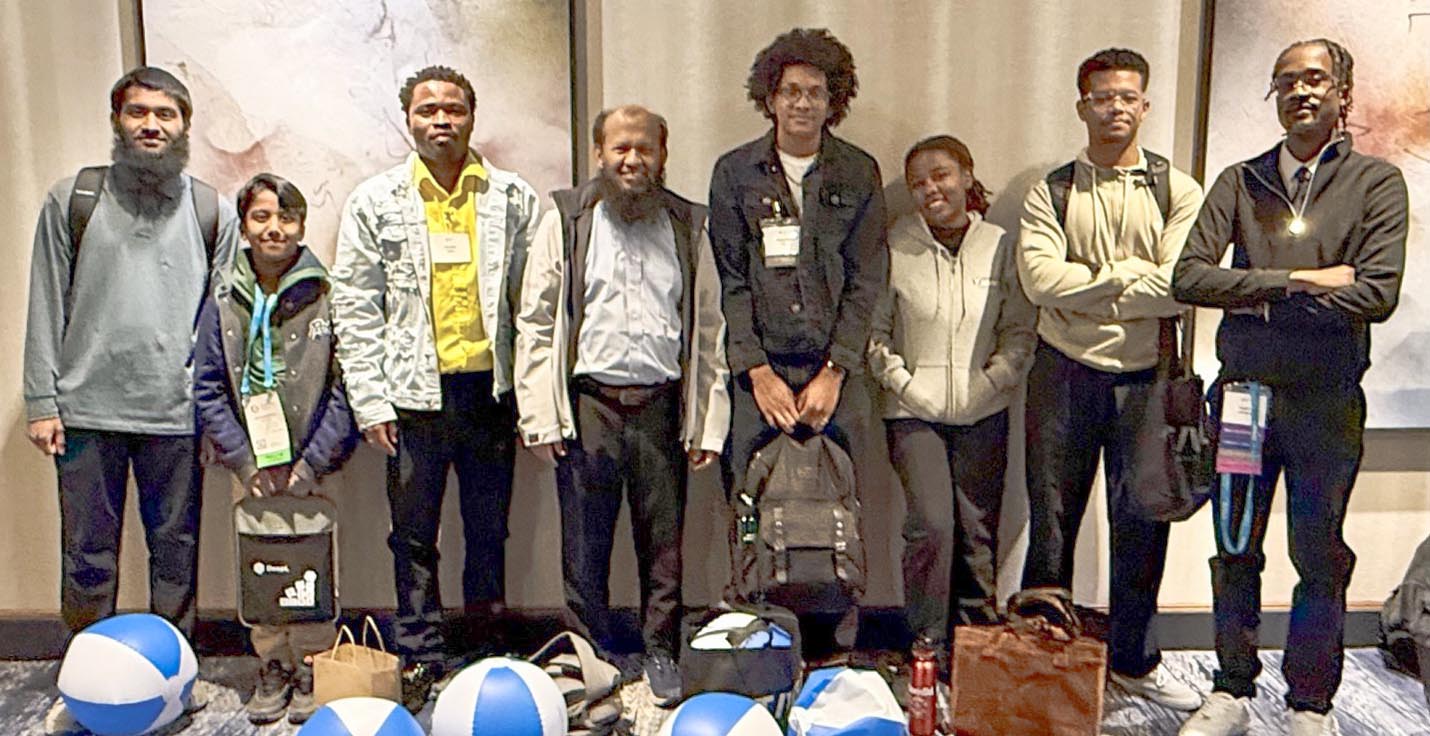 Seven Chicago State University students and CIMST chair Dr. Mohammad Salam stand against a wall for a photo.