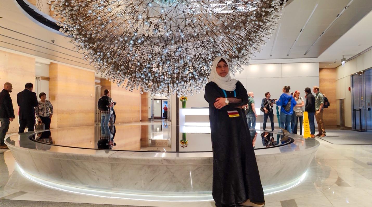 Anees Fatima standing ny sculpture