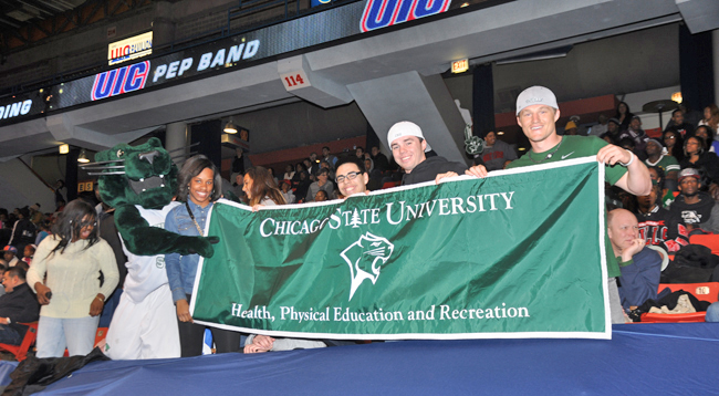 Students actively participating at a CSU basketball game and interacting with the team mascot (Cougar) in the JDC gymnasium