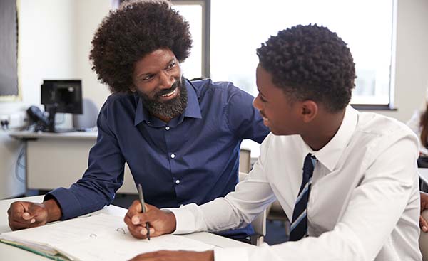 An instructor and student sharing a positive, supportive interaction while working together in a classroom.