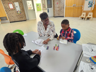 Teacher sitting at a table with children