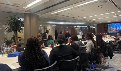 Attendees seated at a large table during an Executive Etiquette workshop in a modern conference room