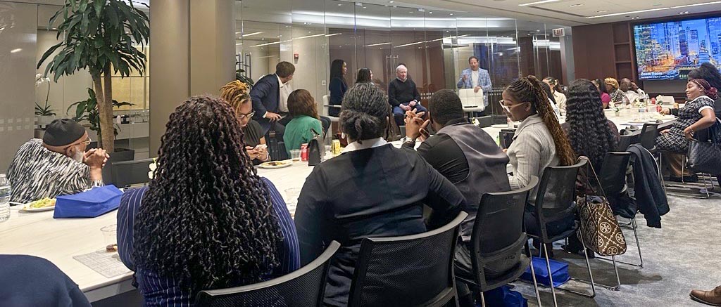 Attendees seated at a large table during an Executive Etiquette workshop in a modern conference room